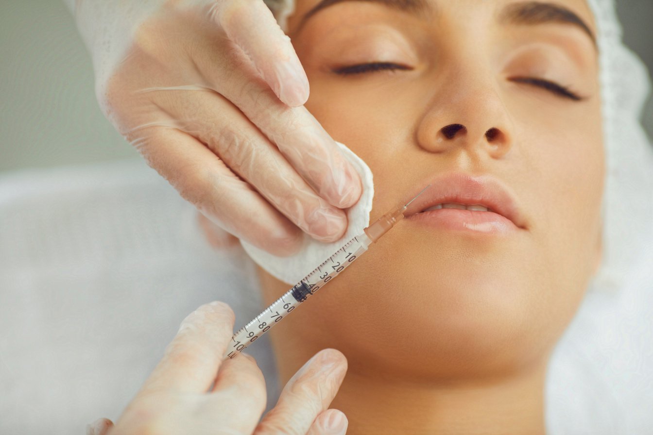 Therapists Hands Injecting Filler Botox for Correction Upper Lip of Young Woman