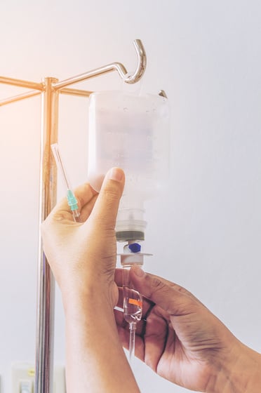 Nurse's Hands Removing IV Fluid Drip 